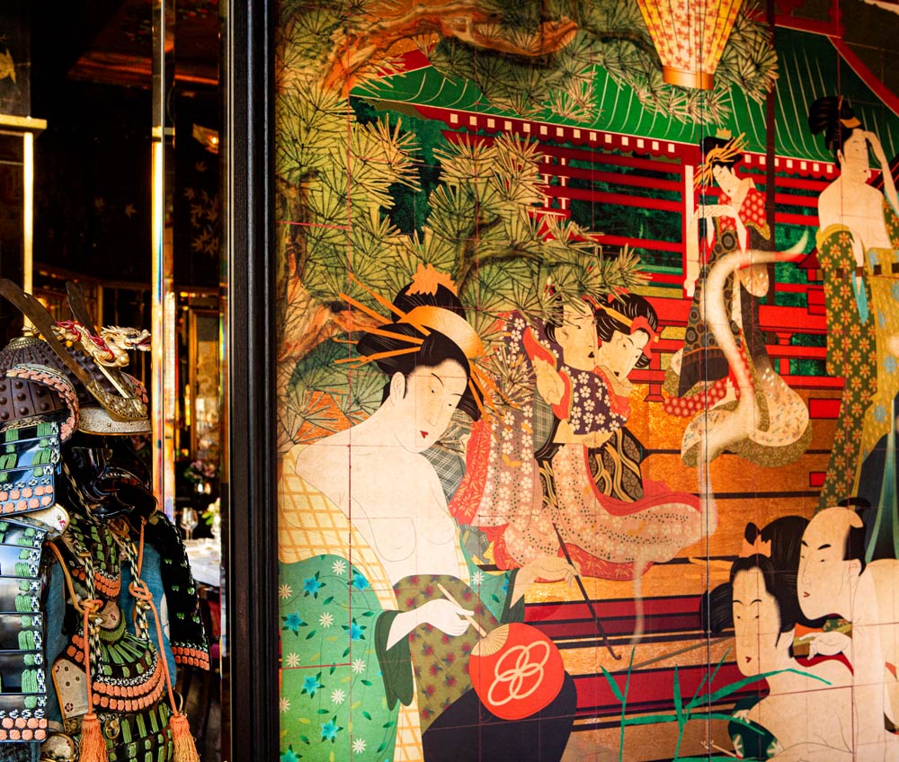 Courtesans in beautifully patterned kimonos are displayed on this panel artwork. Printed onto gold metallic and overprinted with vivid colours the surface shimmers with the restaurant lighting.